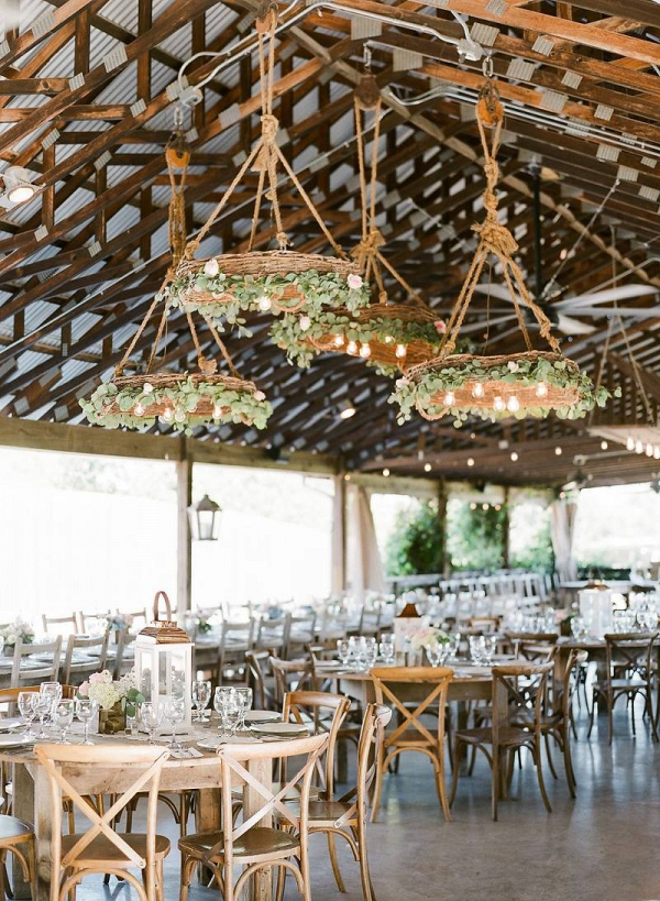 Wedding reception with greenery covered chandeliers