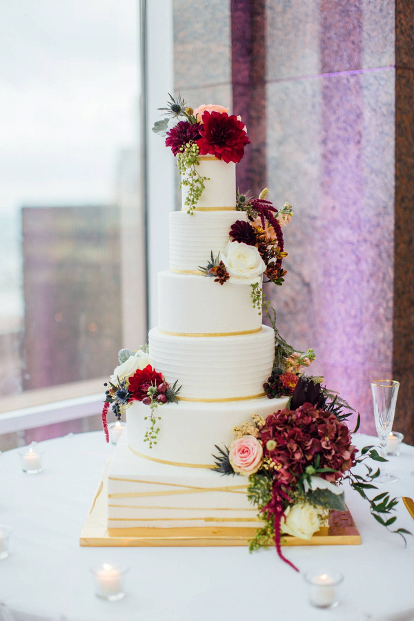 Classic white wedding cake with burgundy florals
