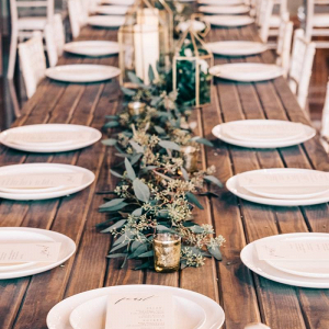 Rustic wedding tablescape with greenery runner and lanterns