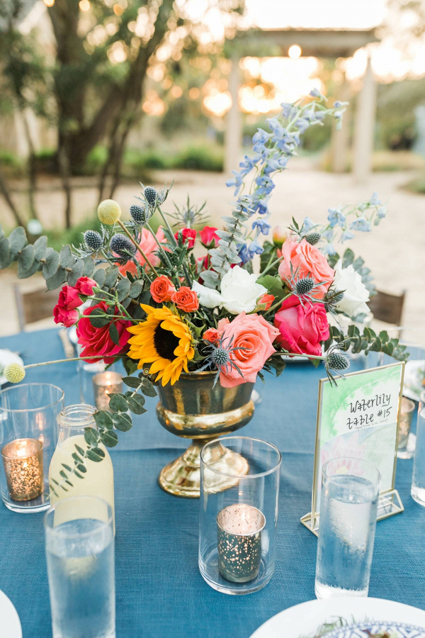 Colorful floral centerpieces in gold urns