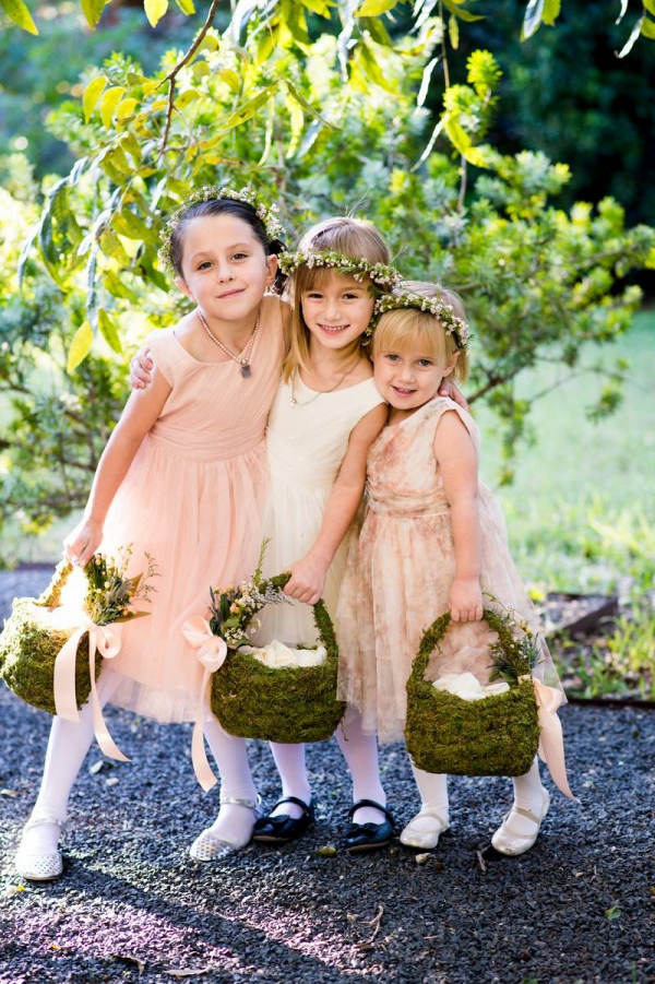 Flower girl in flower crowns with moss baskets
