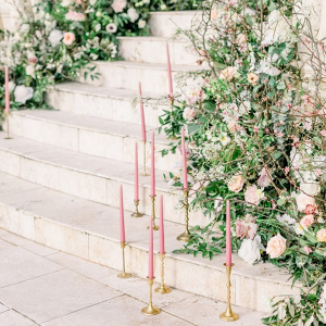 Staircase covered in florals and pink taper candles