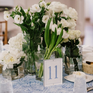 Modern wedding centerpiece with monochromatic florals and printed linens