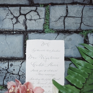 Calligraphy on a Wedding Invitation Surrounded by Flowers