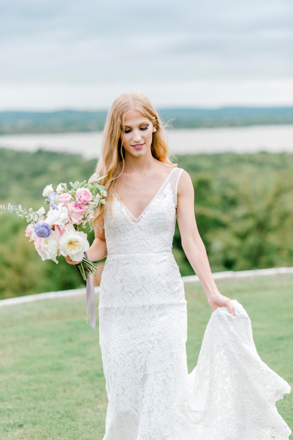 Bride in v-neck lace gown and pastel bouquet