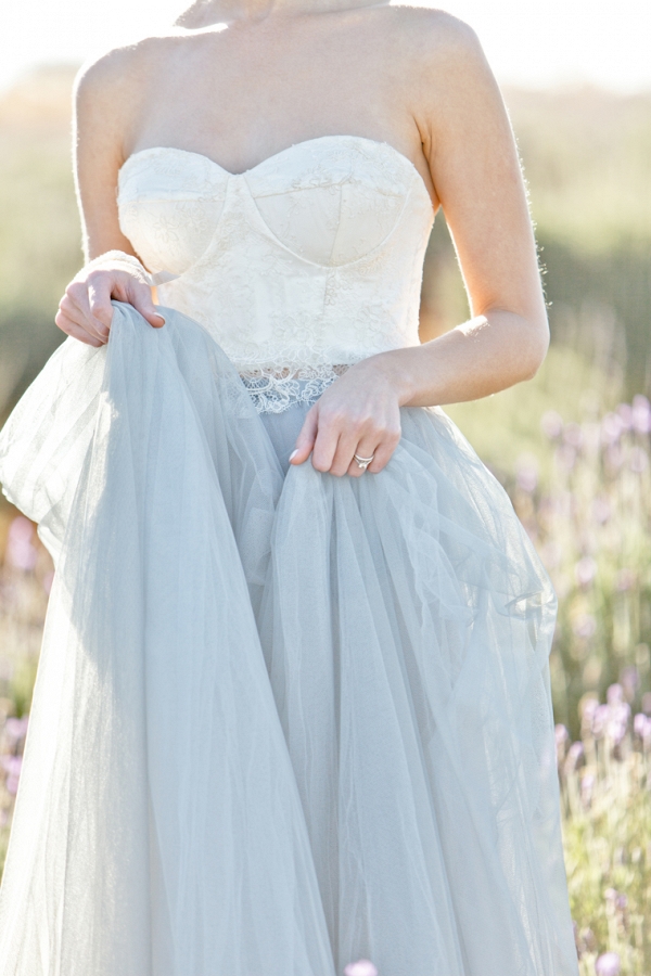 beautiful tulle skirt of the dress held in her hands as she walks through the Lavender 