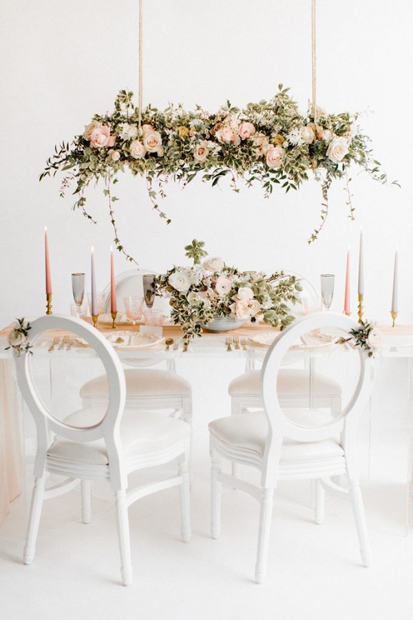 table setting concept with statement floral installation hung over the table  