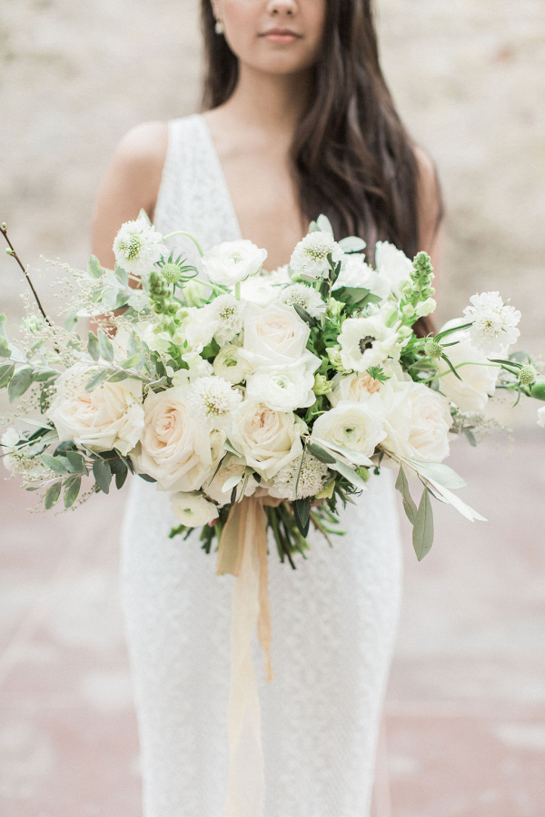 Elegant white bridal bouquet with soft golden silk ribbon