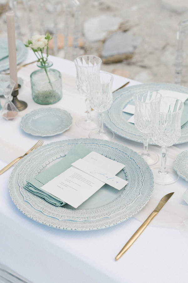 blue white and gold table decor details with blue charger plates and gold cutlery for a beach wedding