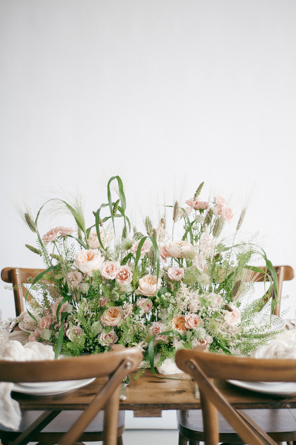 statement floral centrepiece in peach and green with cross back chairs