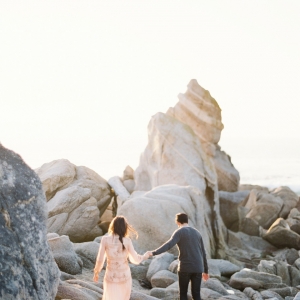 Engaged couple frolicking in the rocks at Big Sur