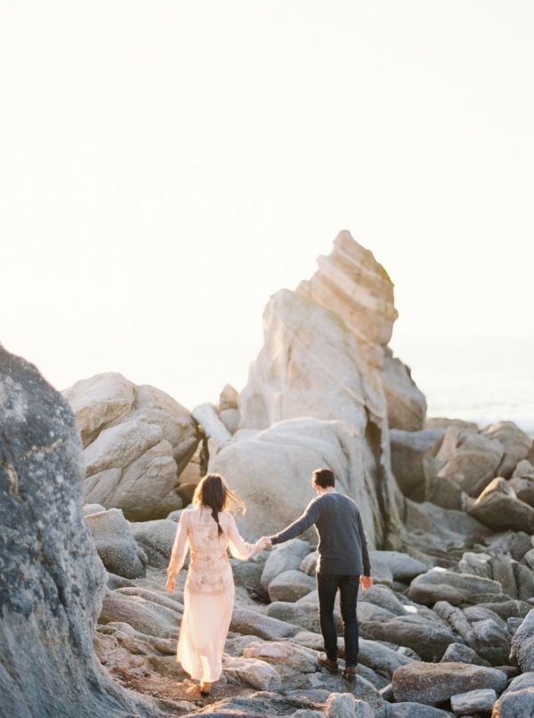 Engaged couple frolicking in the rocks at Big Sur