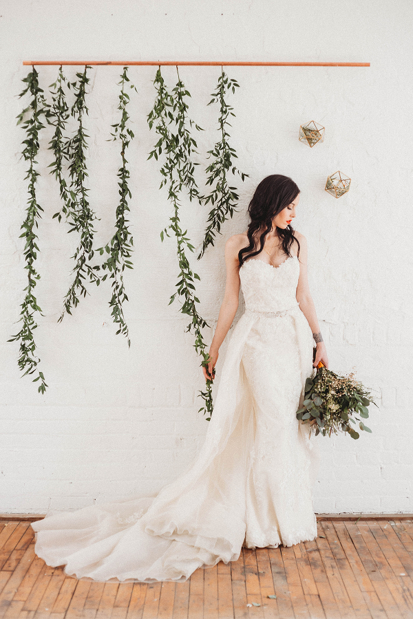bridal portrit with modern backdrop of greenery hanging along the wall