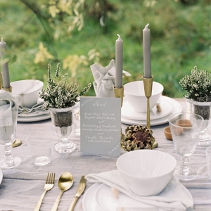 tablescape with tall taper candles white tableware and grey accents