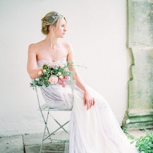 bride sat on a chair decorated with flowers
