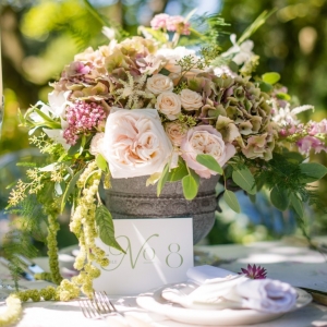 Garden wedding floral centrepiece in a stone urn with garden roses and trailing foliage