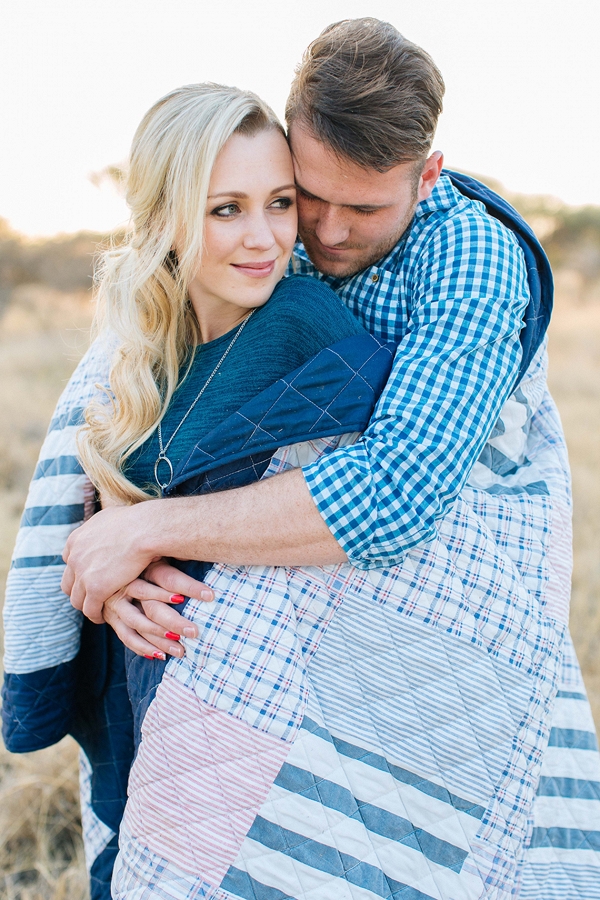 Couple wrapped up in a white and blue patchwork blanket