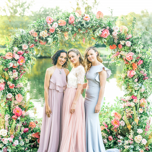 Beautiful pastel mix and match bridesmaids and a colourful floral arch!