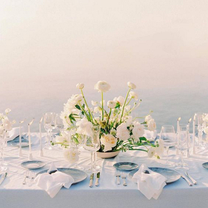 beach wedding table setting in blue with modern white floral centrepiece