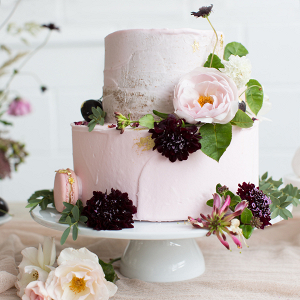 Pretty pink buttercream wedding cake topped with fresh flowers