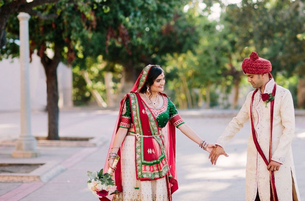 Couple in colorful Indian wedding attire on Bridal Musings