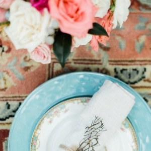 Boho place setting on a rug in a tent on a beach