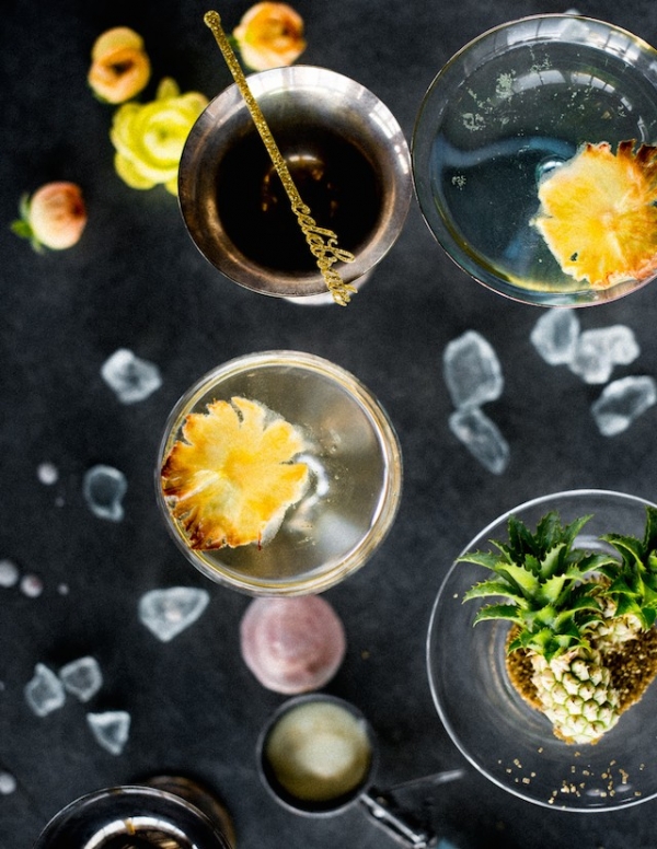 Drinks with mini pineapples and gold glitter stir sticks