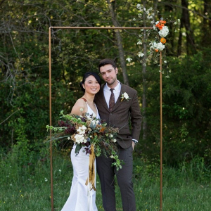 Outdoor wedding ceremony with copper pipe backdrop