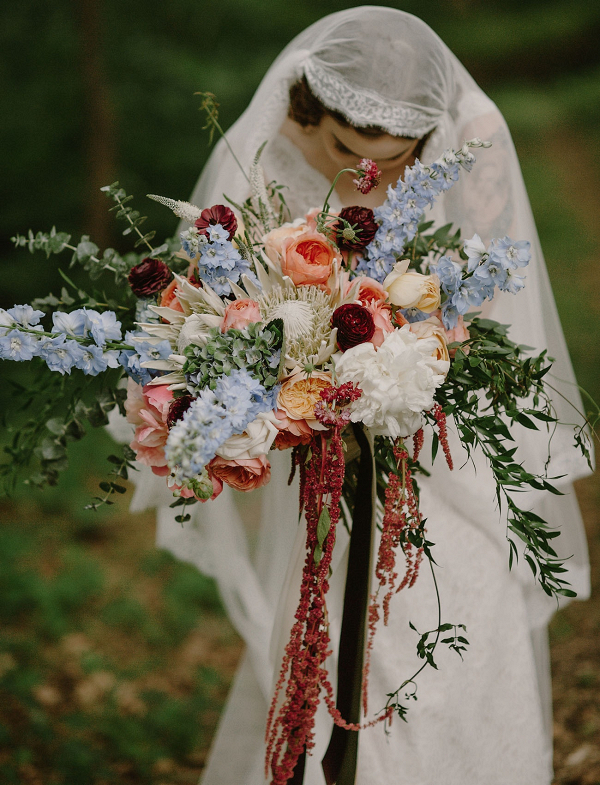 Vintage bride with lush red, blue, and peach bouquet