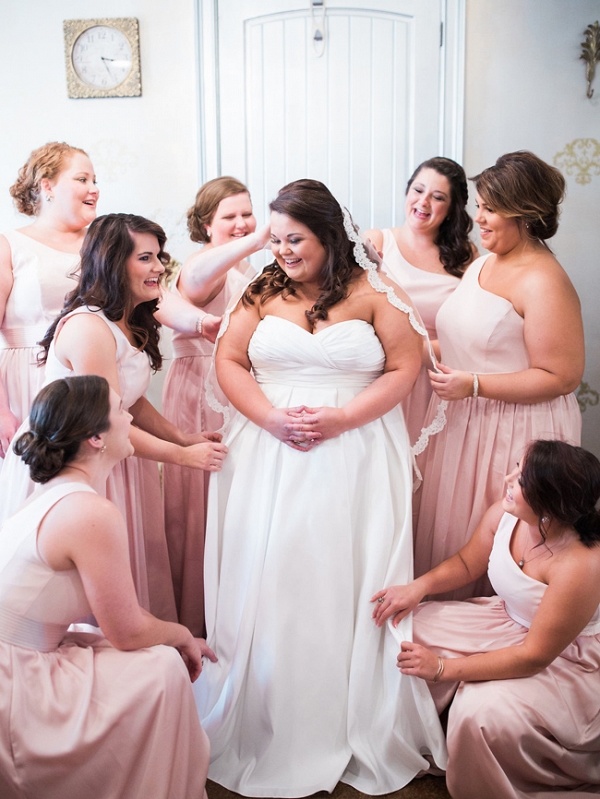 Bridesmaids Assisting Bride With Her Wedding Gown