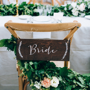 Wood bride chair sign with greenery