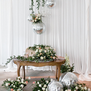 Sweetheart table with greenery and disco balls
