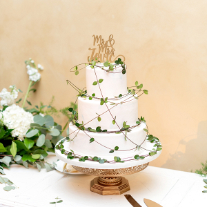 White wedding cake with draped greenery