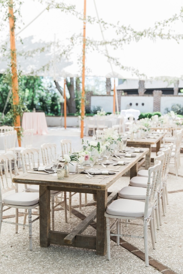 Romantic tented wedding reception with farm tables