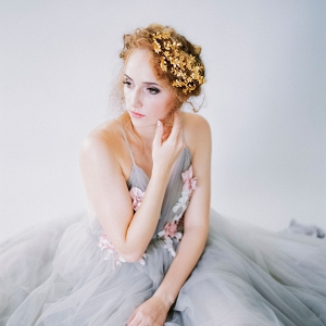 Bride in light gray wedding dress and gold headpiece