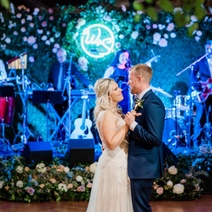 Wedding first dance in front of a blue neon sign