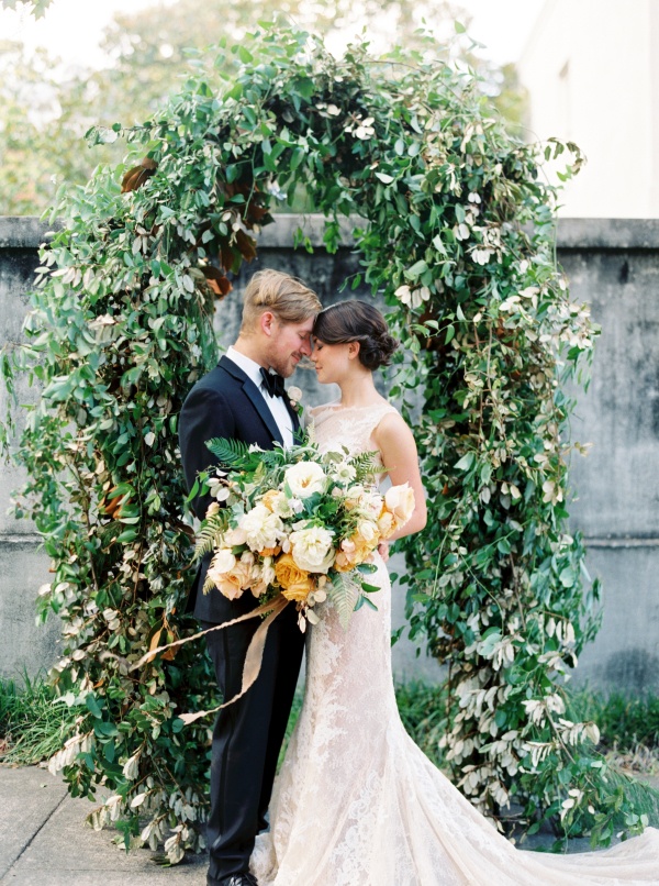 Couple in front of greenery arch on Elizabeth Anne Designs