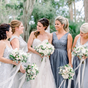 Bridesmaids in mismatched blue and silver dresses