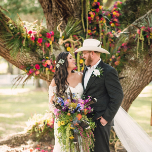 Country wedding ceremony with floral covered oak tree backdrop