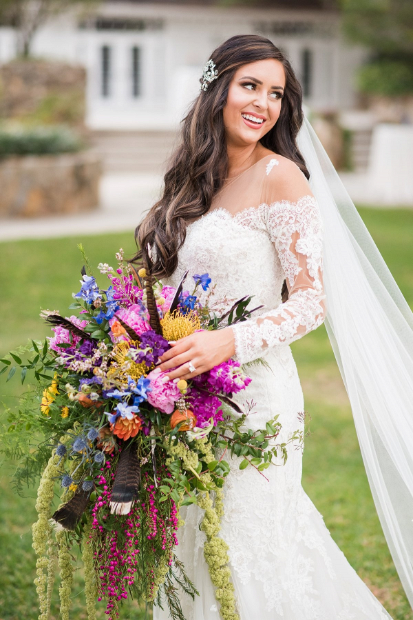 Bride with oversized colorful bouquet and off the shoulder lace gown