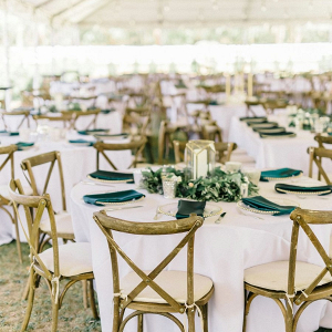Tented wedding reception with lantern and greenery wreath centerpieces