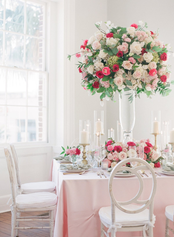 Elegant pink and red wedding table with tall floral centerpiece