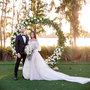Glam bride and groom with circle arch ceremony backdrop