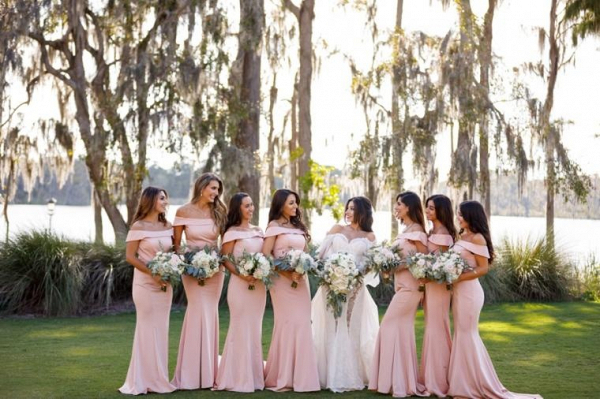Bridesmaids in blush off the shoulder gowns