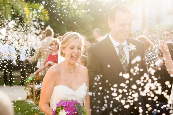 Petals being thrown as couple heads down the aisle