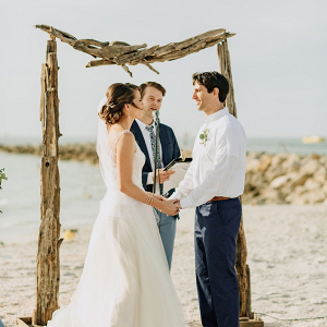 Beach wedding ceremony with driftwood arch