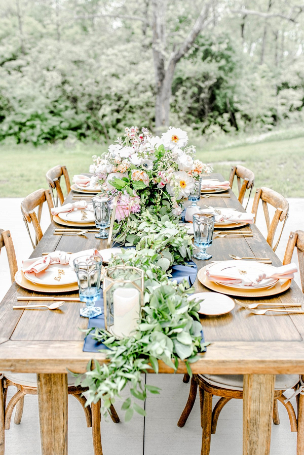 Lush farm table tablescape in gold, pink, and blue