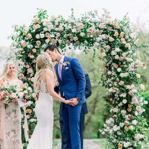 Wedding ceremony with lush floral arch