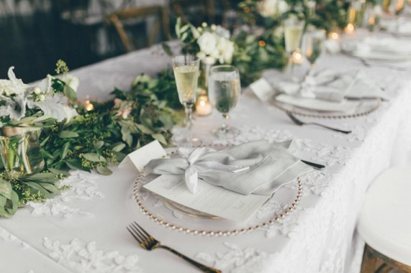 Neutral wedding place setting with garland centerpiece