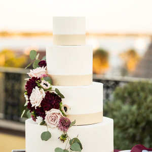 Classic white wedding cake with burgundy and pink fresh florals